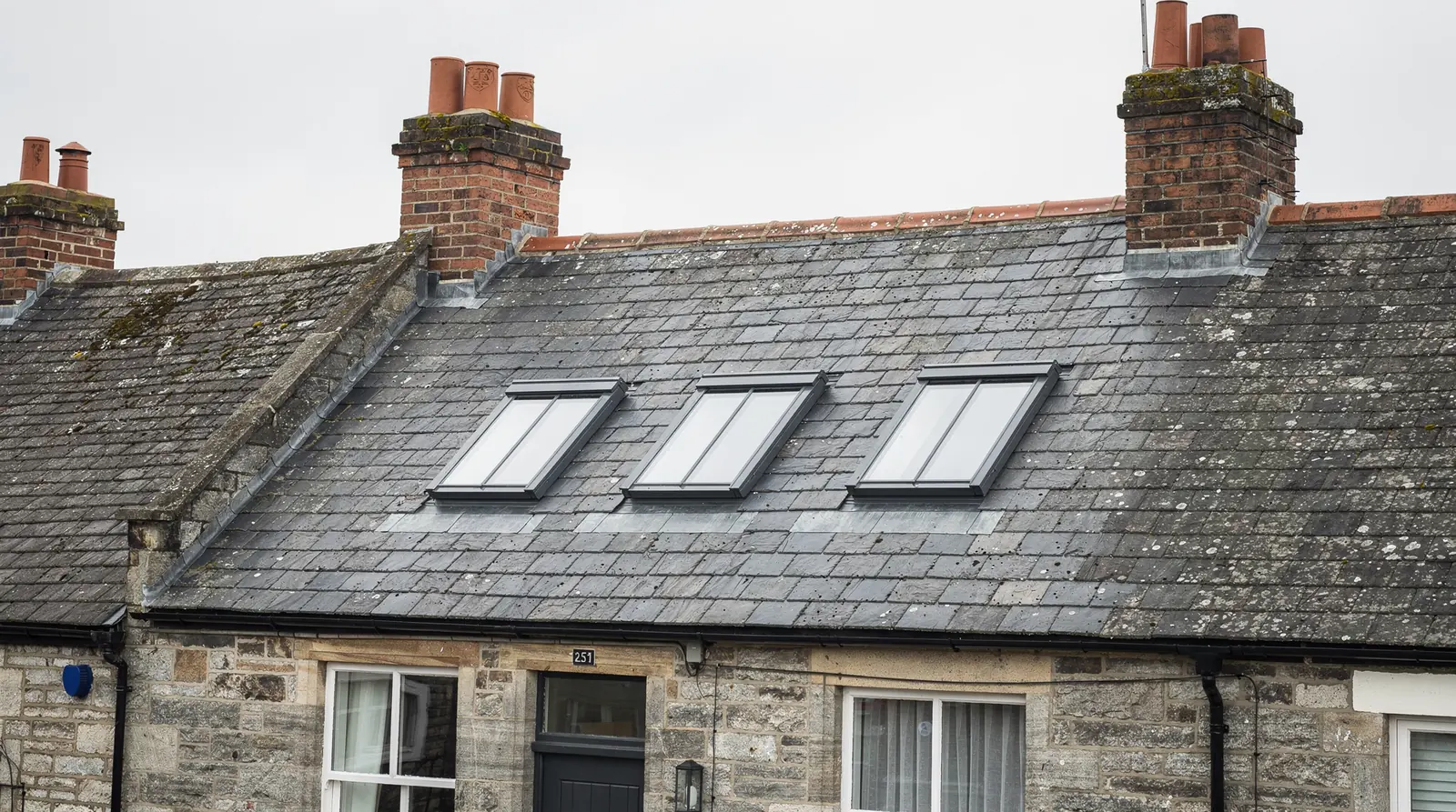 Conservation rooflights flush in the slate roof of stone cottages