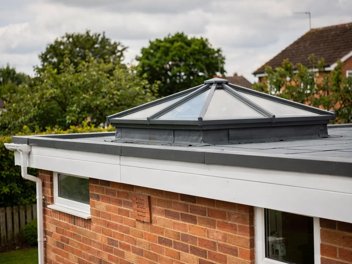 Roof lantern with dark grey frames on a flat-roofed brick extension
