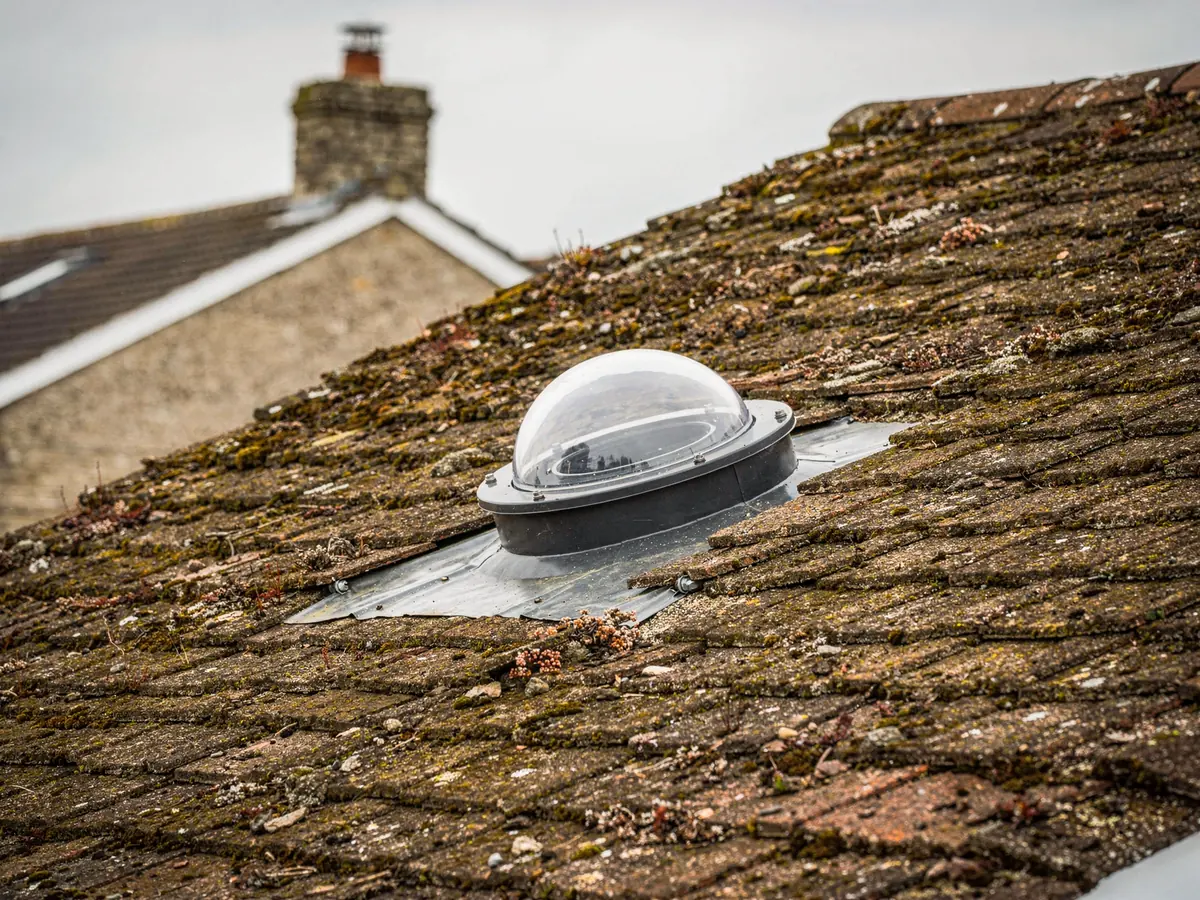 Small round sun tunnel dome on a tiled roof