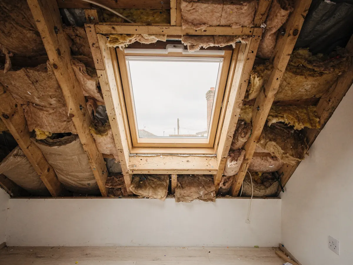 New roof window fitted between rafters before plastering